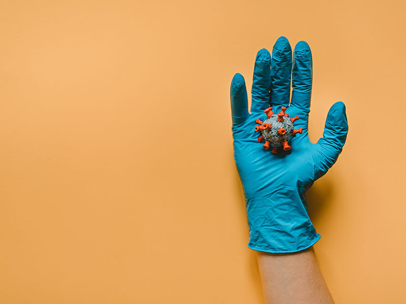 gloved hand holding Covid-19