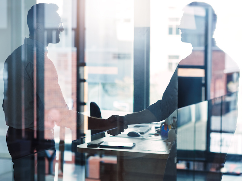 Shot of two businessmen shaking hands in an office