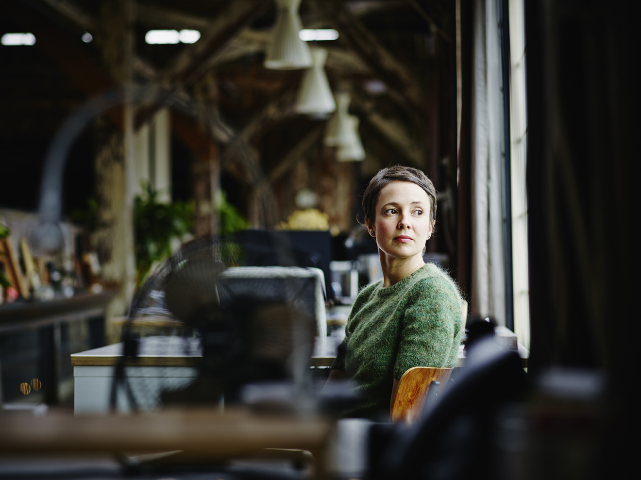 Businesswoman at workstation looking out window alternate text for this image