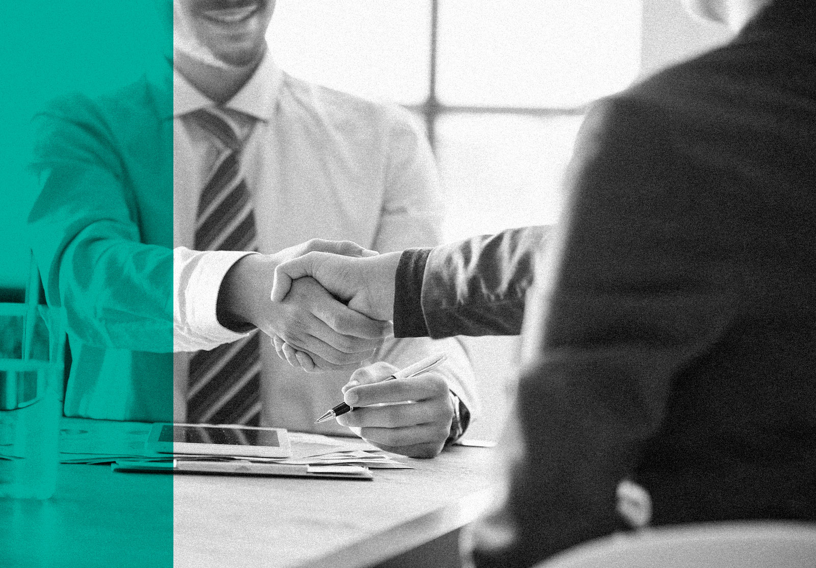 Two men shaking hands on desk