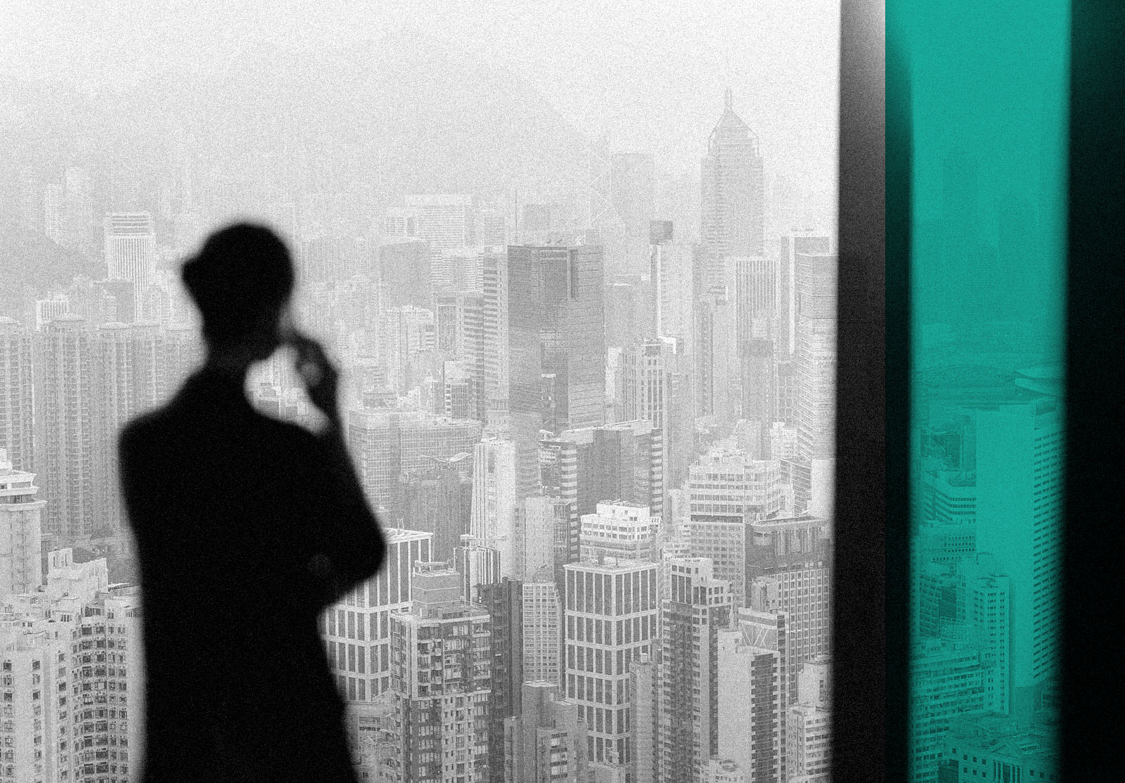 Blurry silhouette of businesswoman talking on phone from office window overlooking cityscape