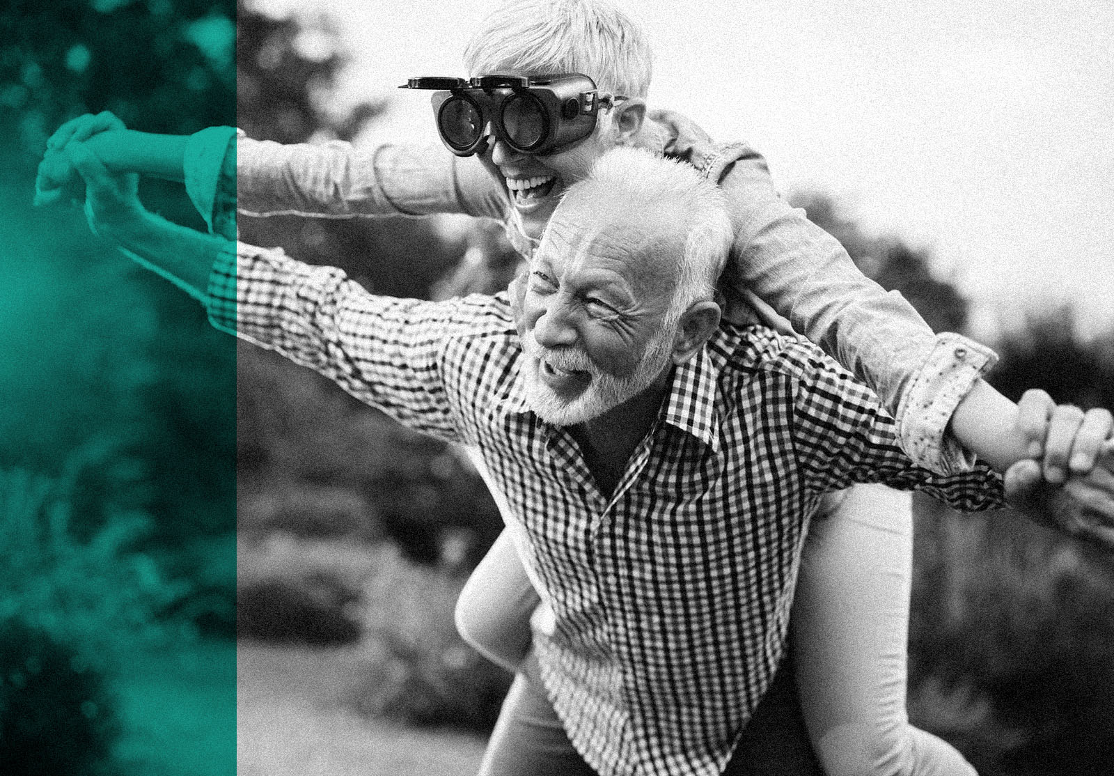 Happy mature couple having fun while piggybacking with their arms outstretched in nature.