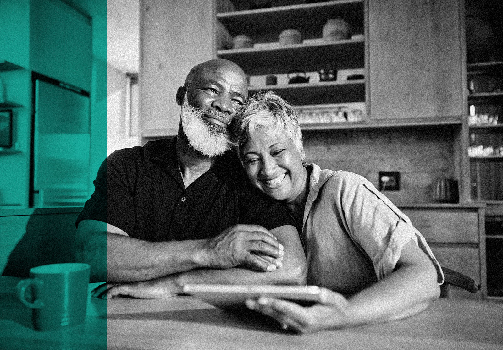 Couple looking at pension savings on a tablet at home at the kitchen table