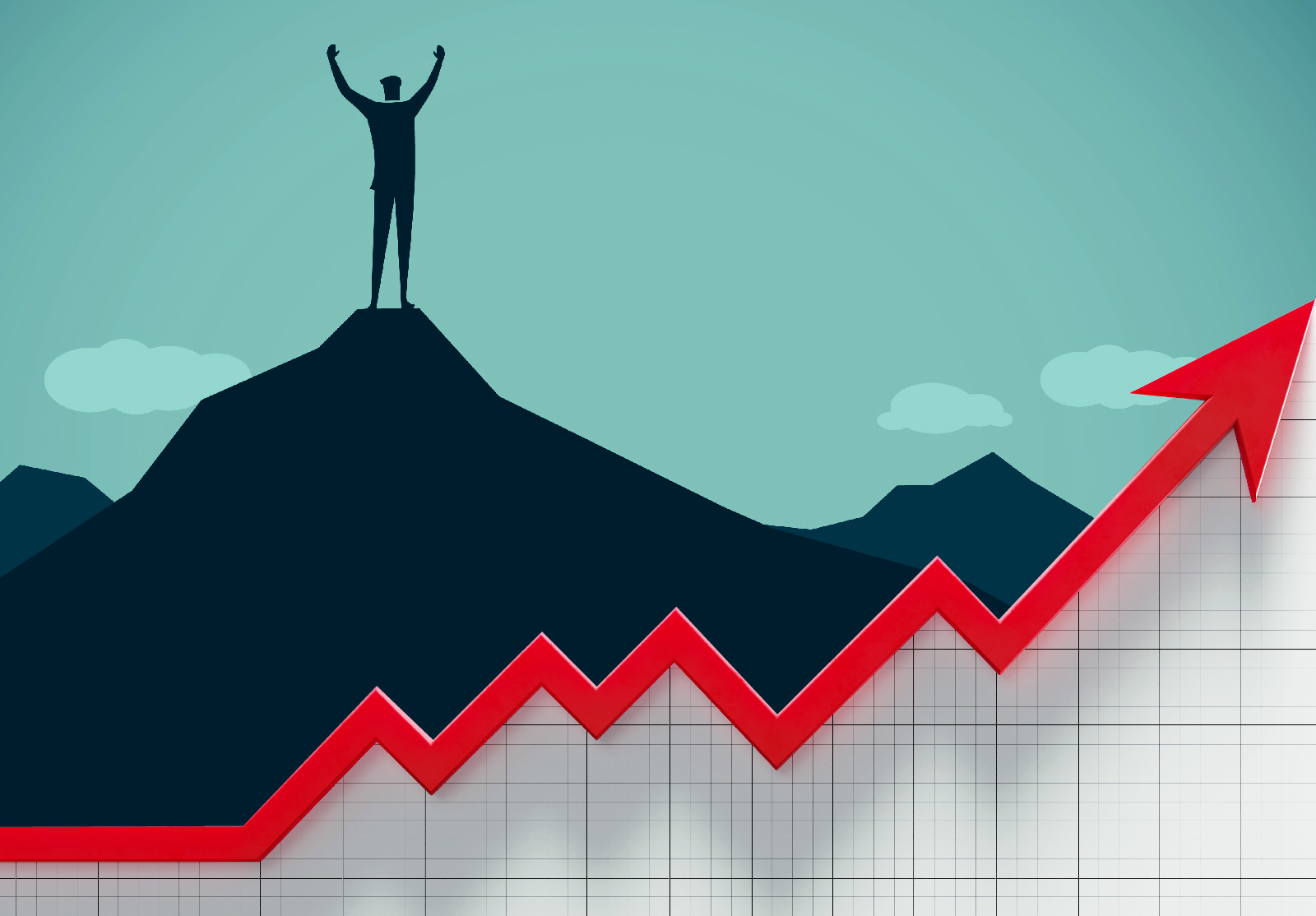 Man standing on top of mountain raises his hands up in victory