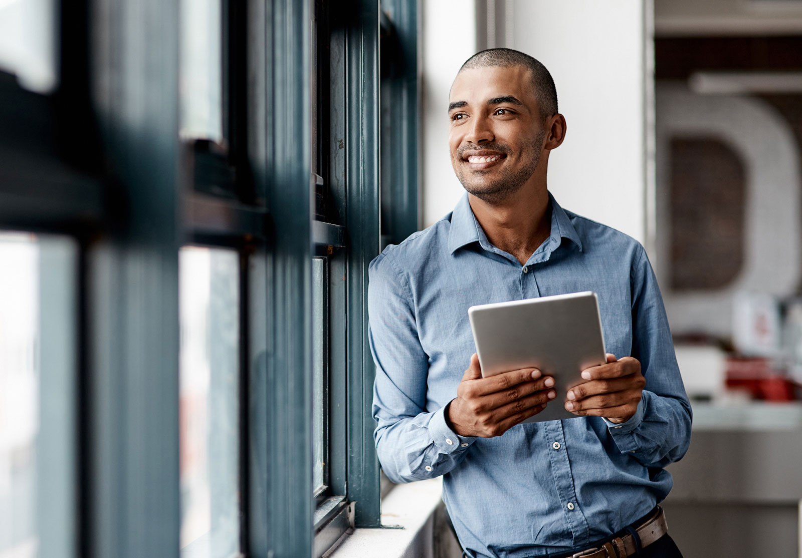 Advisor holding a tablet looking out a window