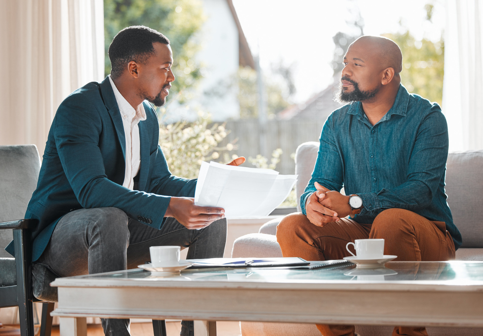 A mature man having a meeting with a finance broker in a living room