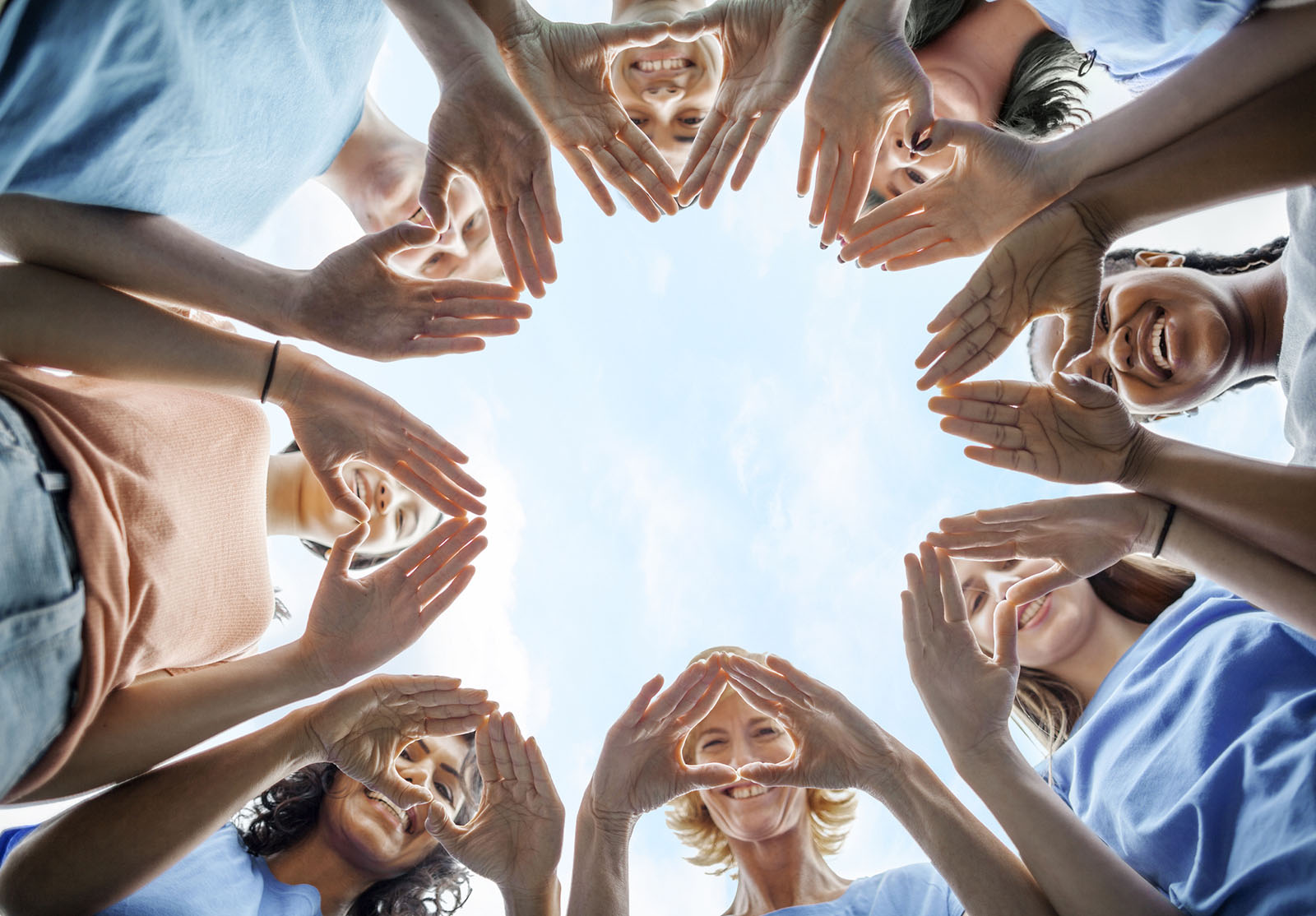 People stand in circle as community volunteers to show support and commitment to teamwork
