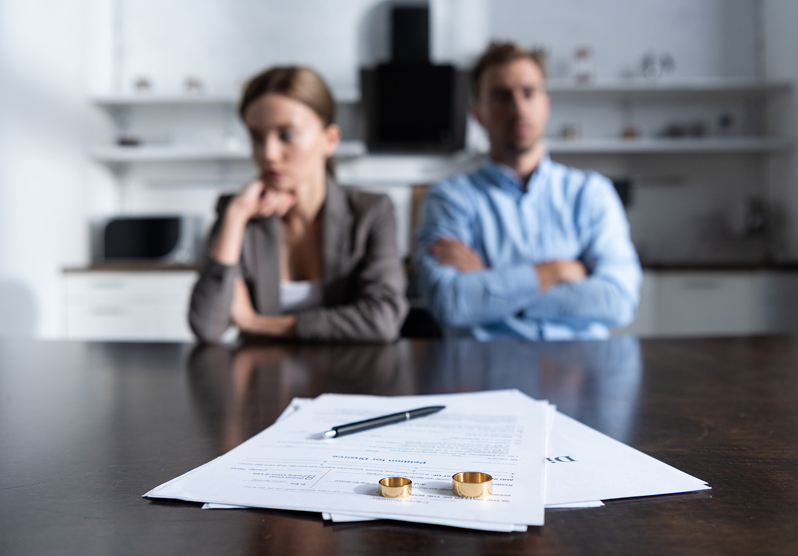 selective focus of couple sitting at table with divorce documents
