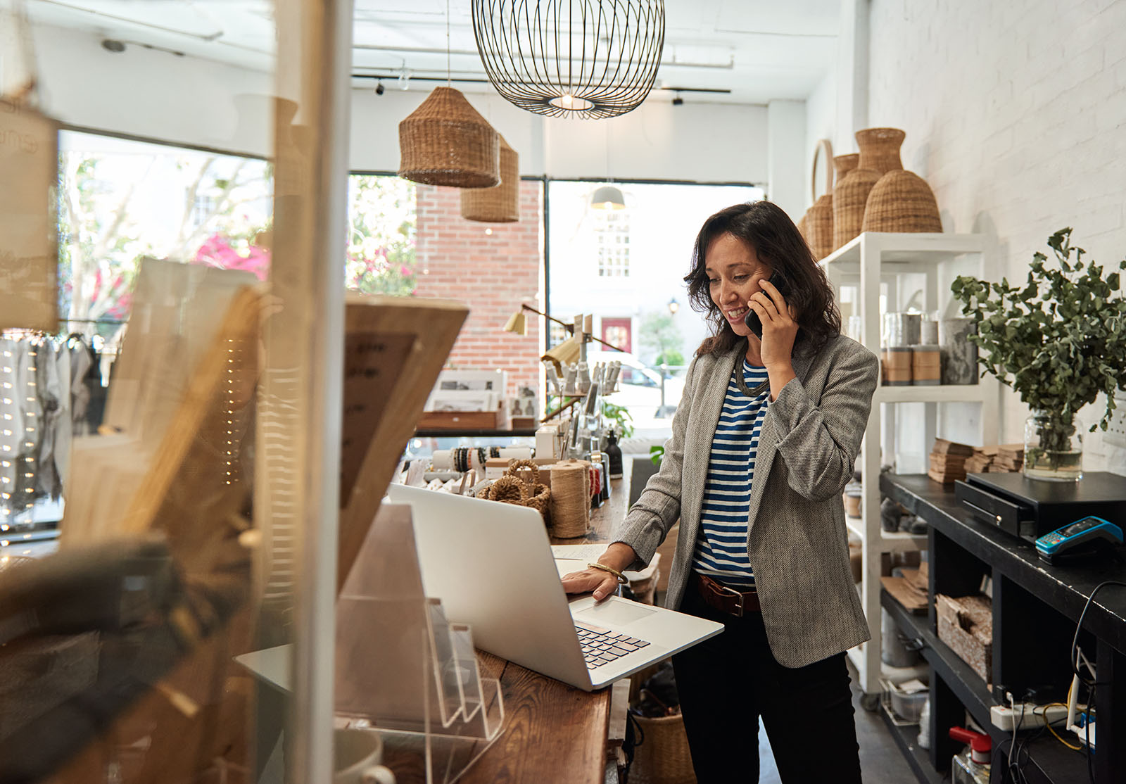Smiling woman talking on a cellphone in her store