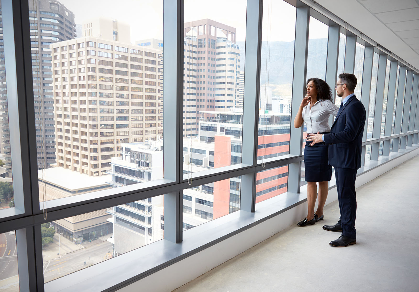 Portrait Of New Business Owners By Empty Office Window