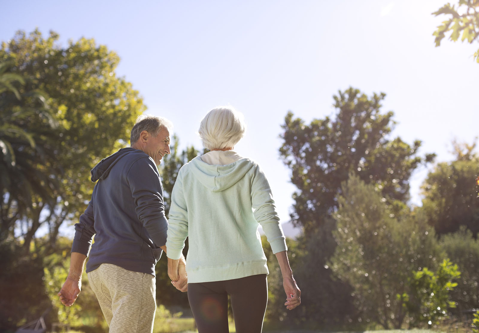 Senior couple holding hands and walking in park