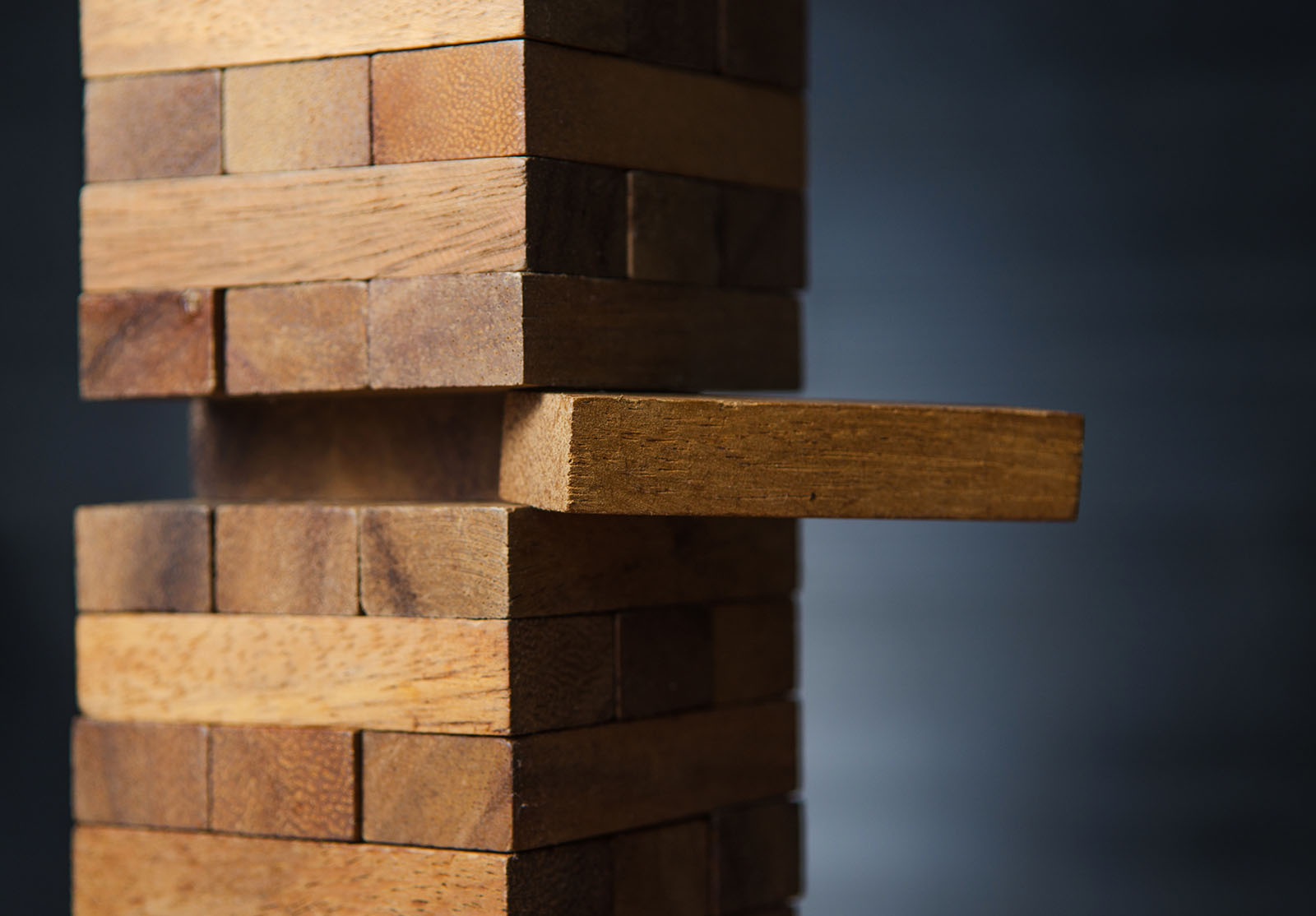 Closeup take one block on The tower from wooden blocks, dark ton