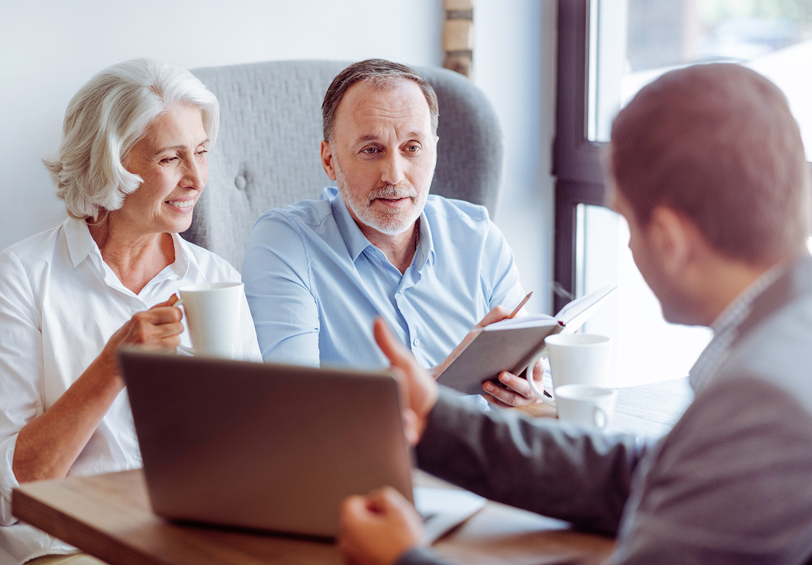 Positive aged couple consulting with insurance agent