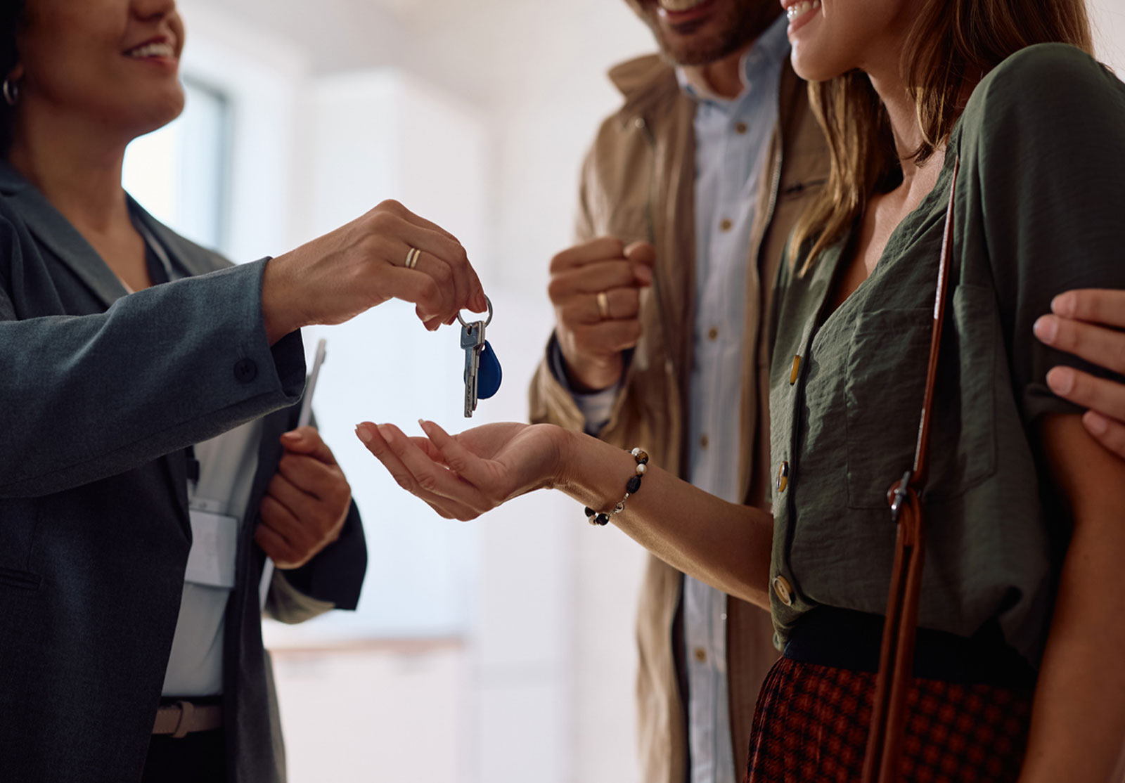 Close up of couple receiving keys of their new home from real estate agent