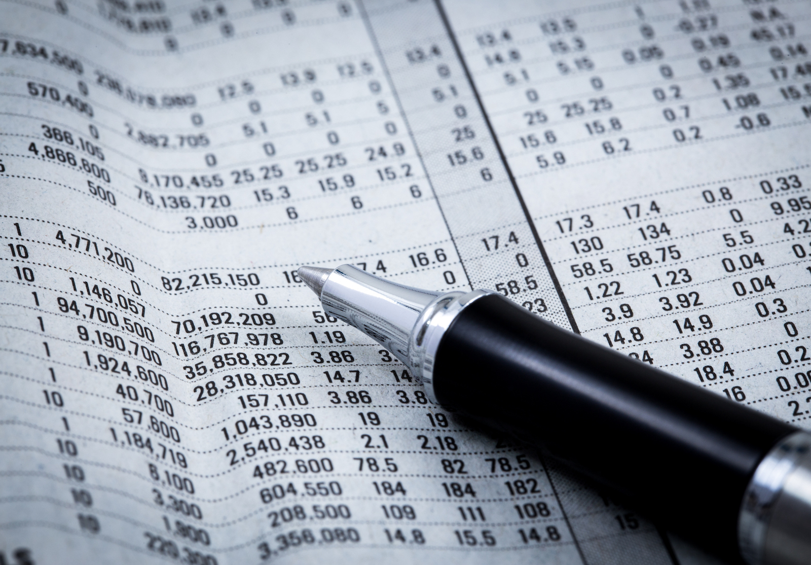 pen resting on world currency figures alternate text for this image
